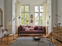 Wohnzimmer mit Sofa und Vitra Kissen in Rosa- und Lilatönen, dekorative Sofakissen für gemütliches Ambiente.