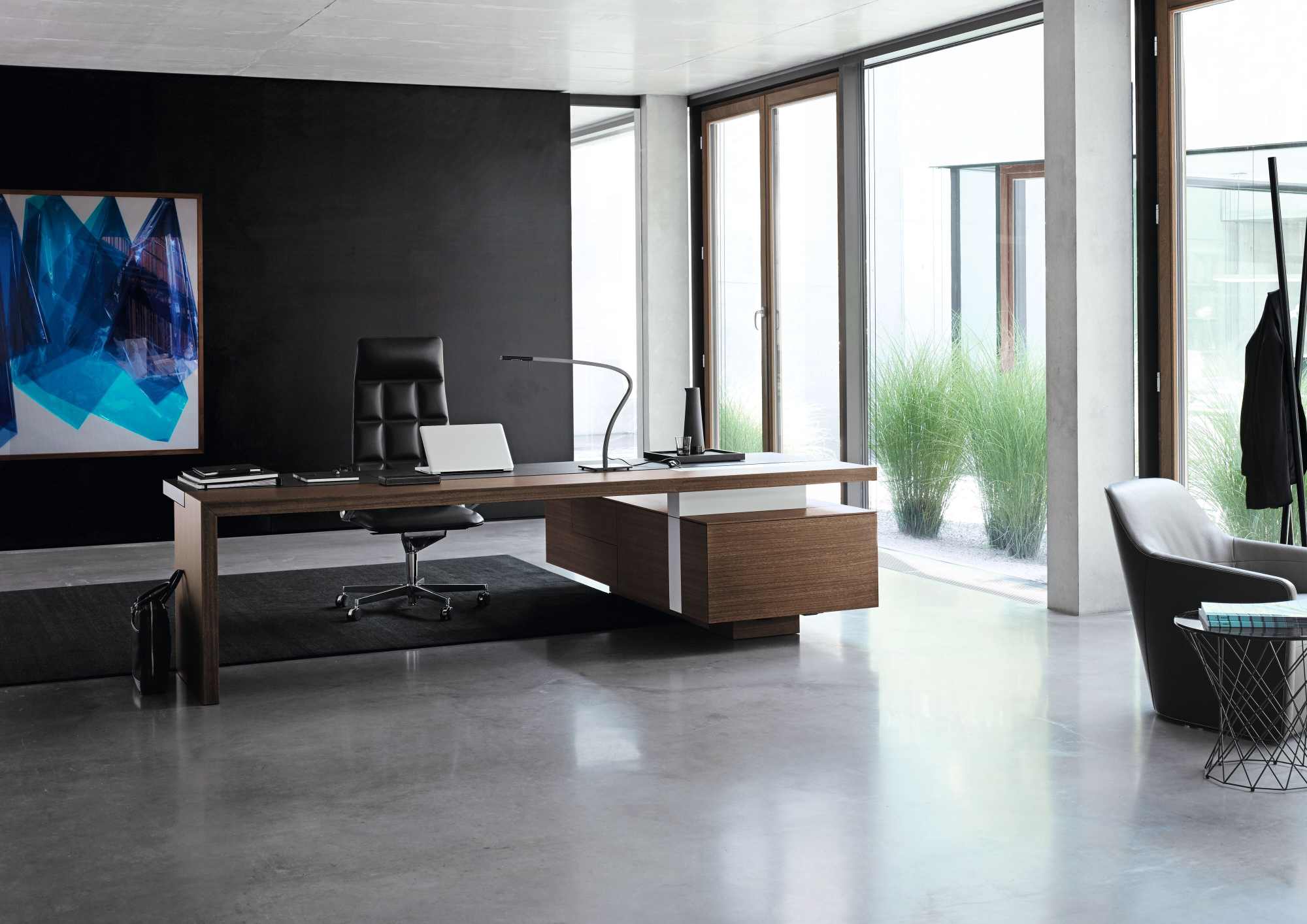 Büro mit modernem Schreibtisch, schwarzem Bürostuhl und einem 520 Foster Sessel von Walter Knoll.
