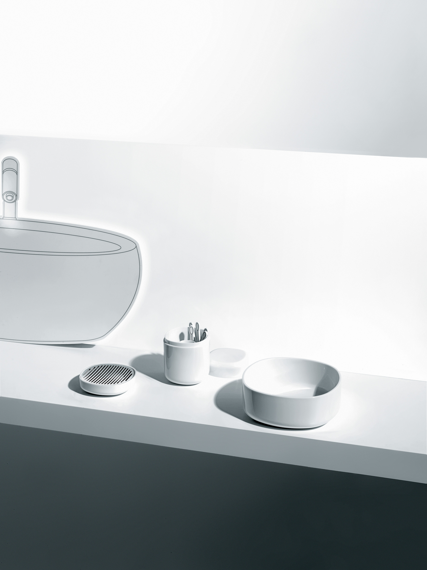 Weiße Birillo Seifenschale von Alessi, zusammen mit Zahnputzbecher und Seifenspender im minimalistischen Badezimmer.