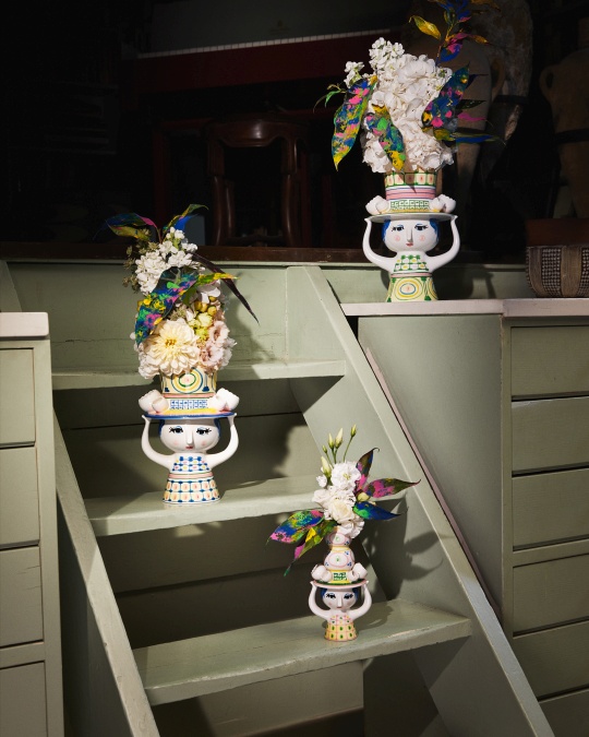 Drei Bjorn Wiinblad Kerzenständer "Lady with Hat" auf einer Treppe, dekoriert mit Blumen und bunten Blättern.