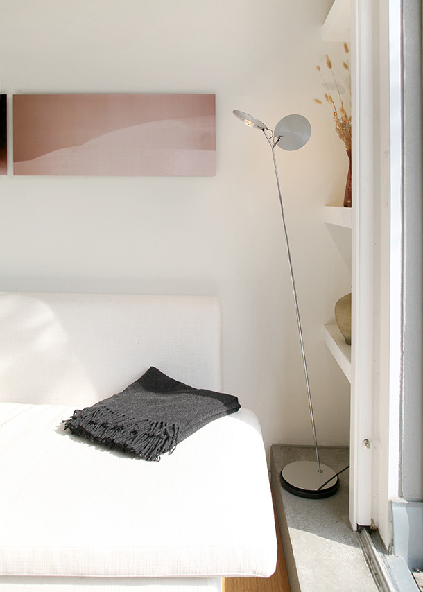 OyO S Stehleuchte von Baltensweiler im modernen Wohnzimmer neben Sofa und Regal.