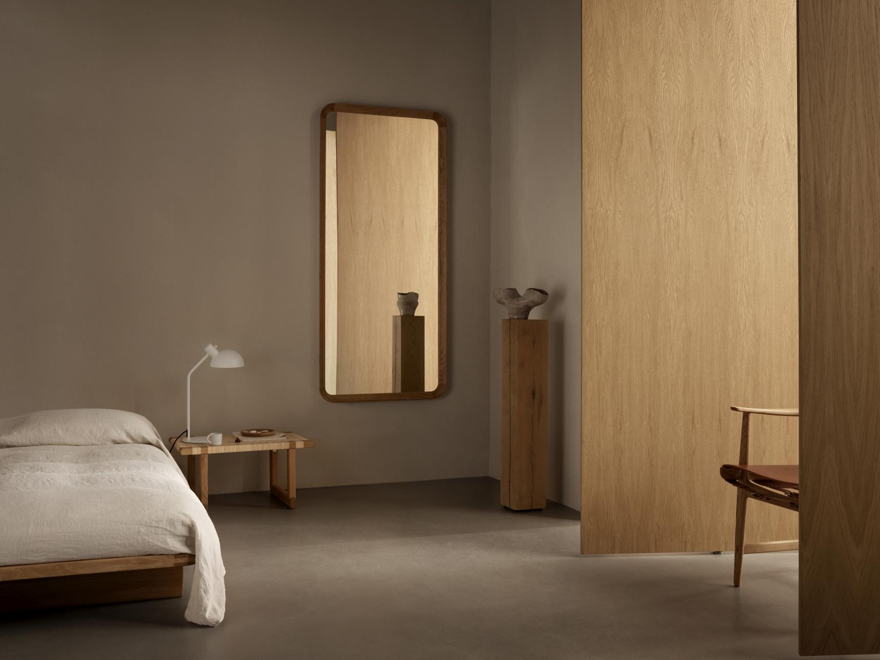 VLA62 Radio House Spiegel von Carl Hansen in Schlafzimmer mit Bett und Lampe.