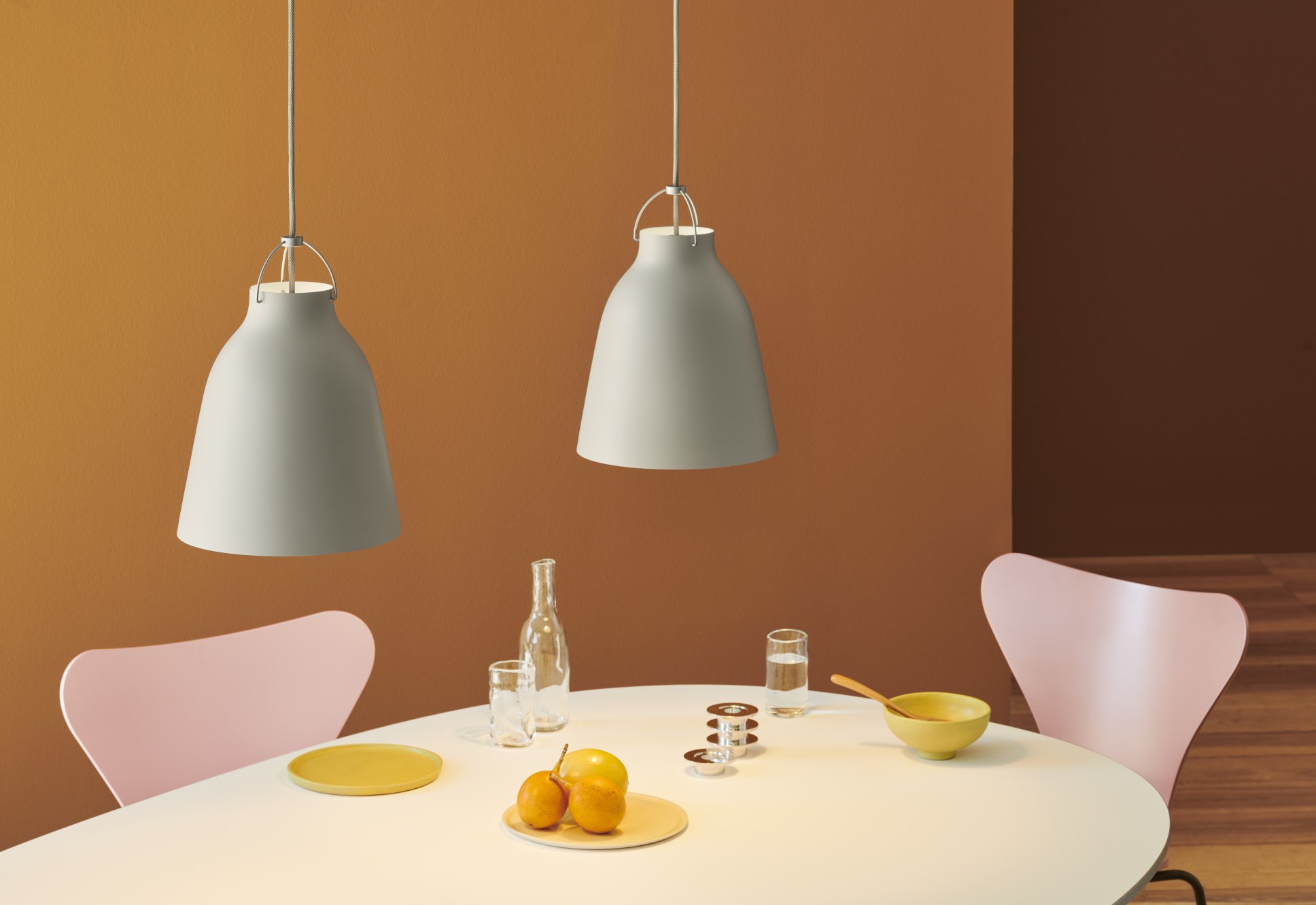 Fritz Hansen Super Elliptisch Esstisch mit Pendelleuchten, Stühlen und Tischdekoration in einem modernen Esszimmer.