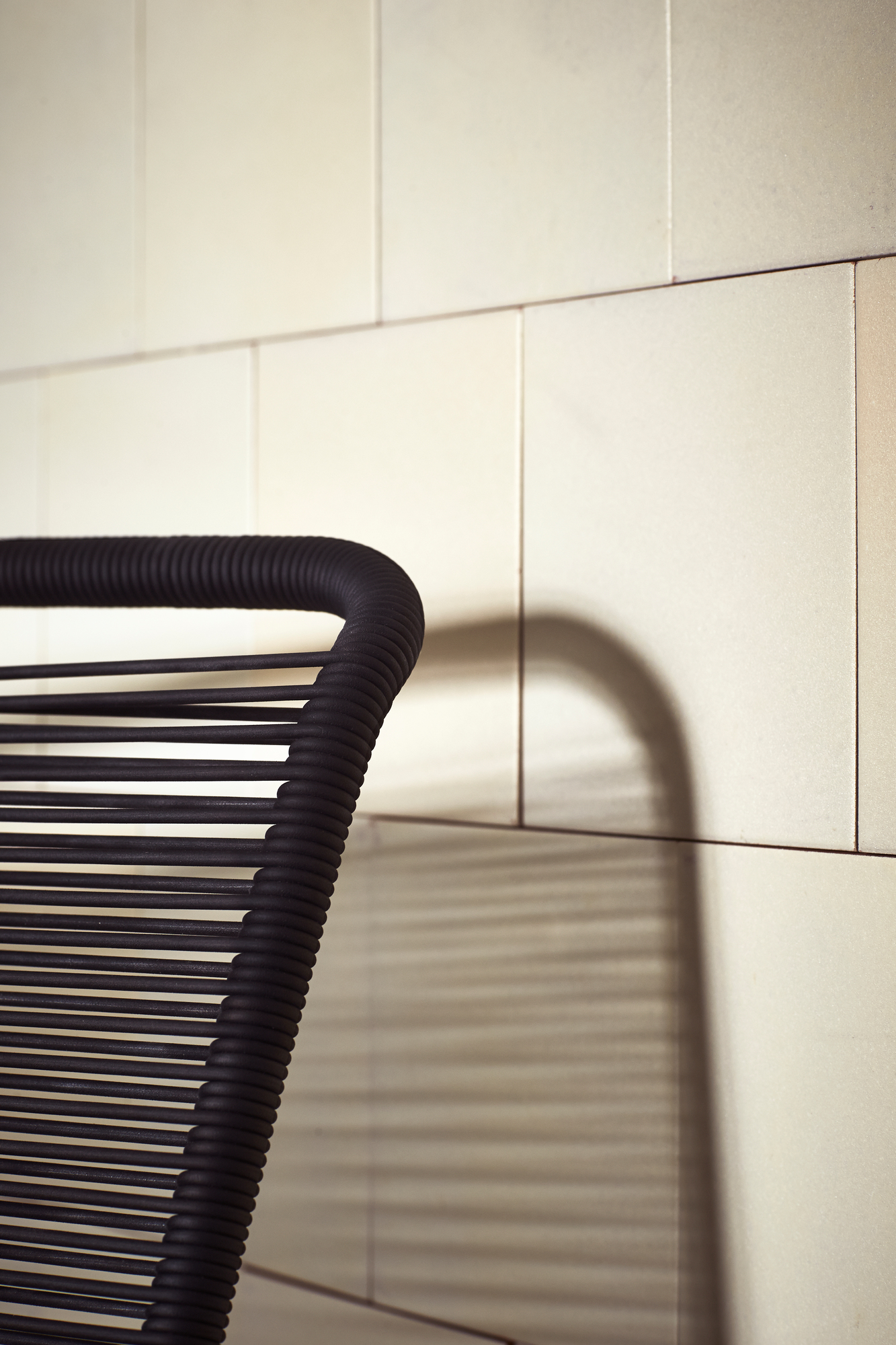 Detailaufnahme: Schwarzer Panton One Stuhl mit Schnurgeflecht vor hellem Hintergrund. Design Stuhl.