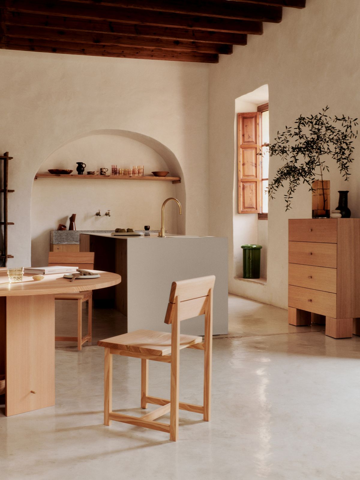 Ferm Living Visit Esszimmerstuhl aus hellem Holz im minimalistischen Esszimmer mit Holztisch und Kommode.