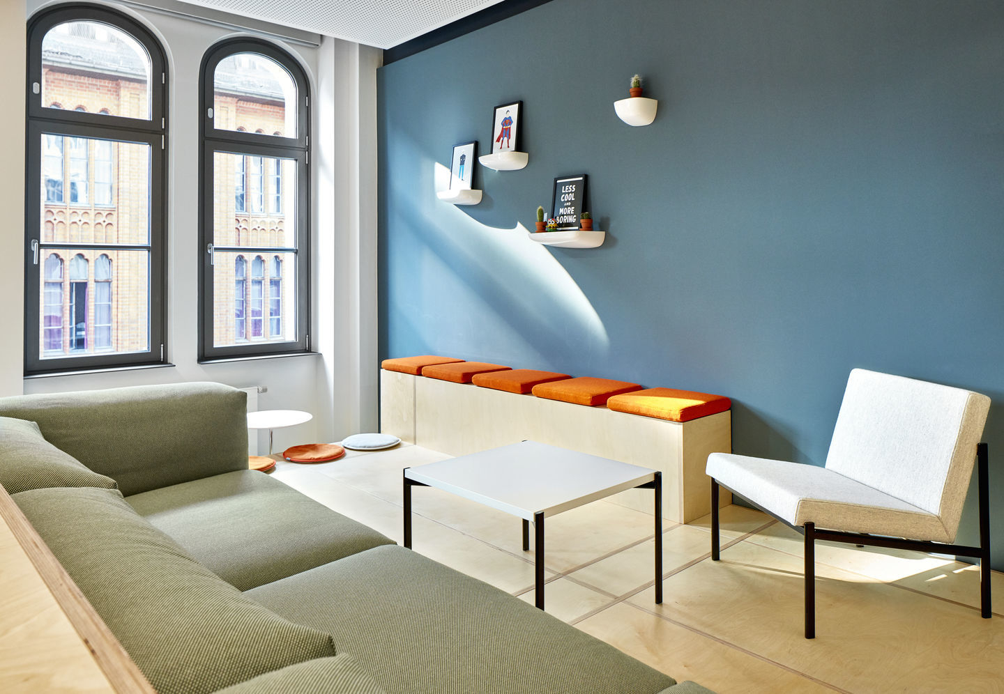 Wohnraum mit blauer Wand und Vitra Corniches Wandboards zur Dekoration von Wohnaccessoires und Bildern.