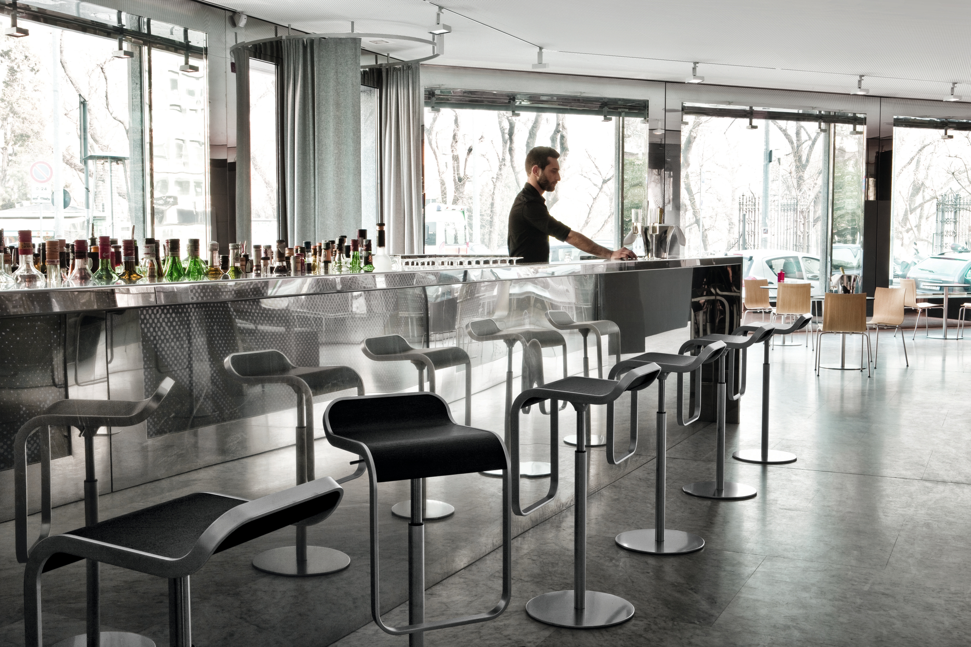 LEM Barhocker von La Palma mit matt verchromtem Gestell vor einer Bar. Design Barhocker.