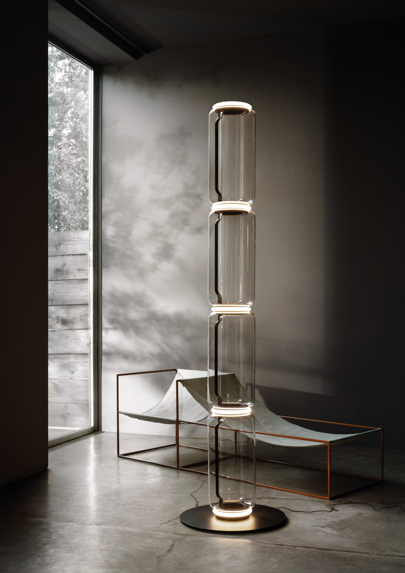 Noctambule Stehleuchte von Flos, modernes Design mit Glaszylindern und warmem Licht, ideal für Wohnzimmer.