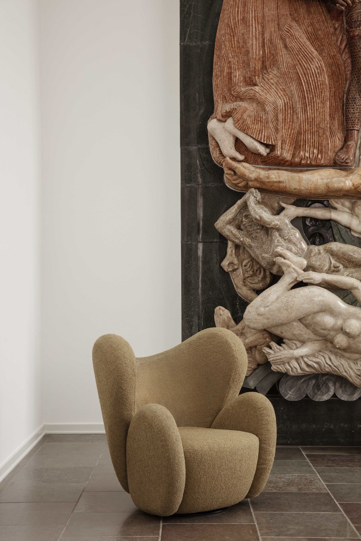 Beiger Big Big Lounge Chair Sessel von NORR11 mit Bouclé-Bezug vor einer Wand mit Skulptur.