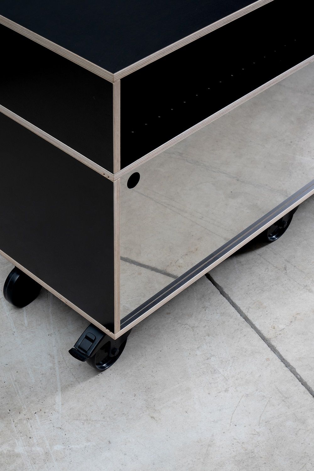 Detailaufnahme des Rockboard Sideboards von Nils Holger Moormann in Schwarz mit Rollen und Regalfächern.