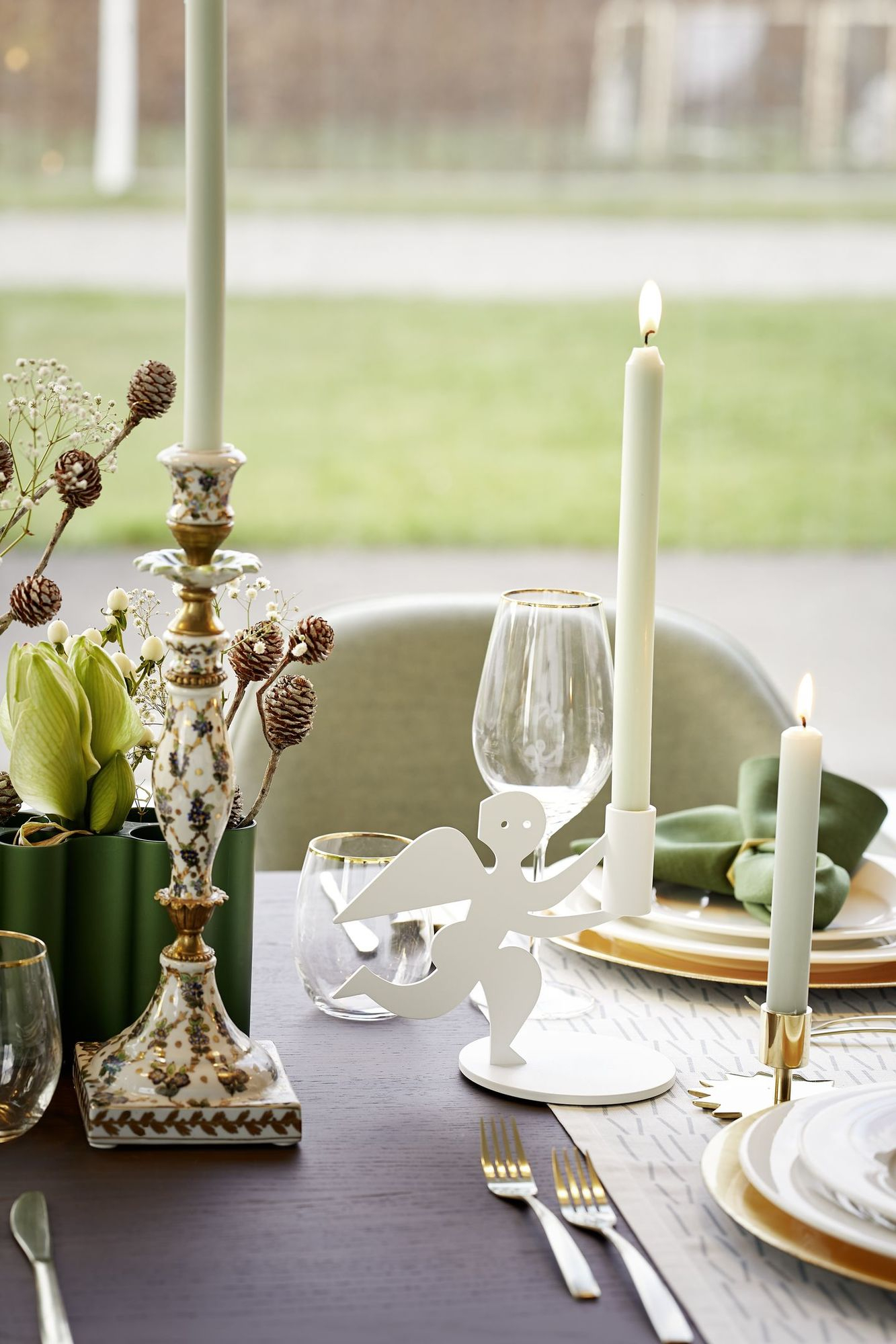 Festlich gedeckter Tisch mit Kerzen, Blumenschmuck, Geschirr und einem Vitra Softshell Chair im Hintergrund.