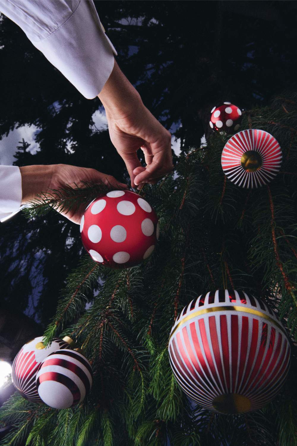 Alessi Weihnachtskugeln: Hand dekoriert Tannenbaum mit roten Delight Christbaumkugeln mit Punkten und Streifen.