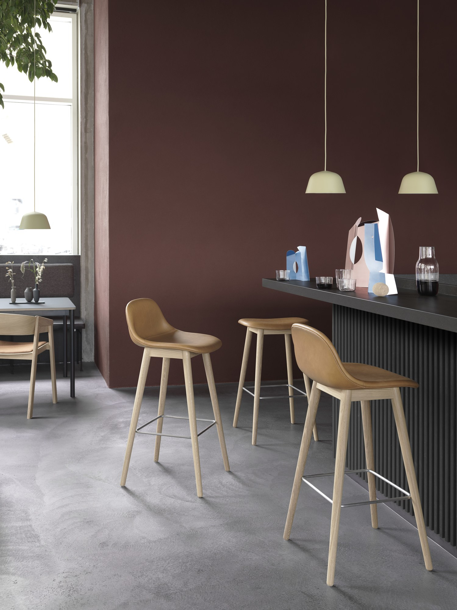 Innenaufnahme mit Ambit Pendelleuchten von Muuto in Hellblau über einer Bartheke.