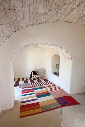 Farbenfroher Medina Teppich von Nanimarquina (200x300 cm) in einem Raum mit Gewölbedecke. Handgefertigter Wollteppich.