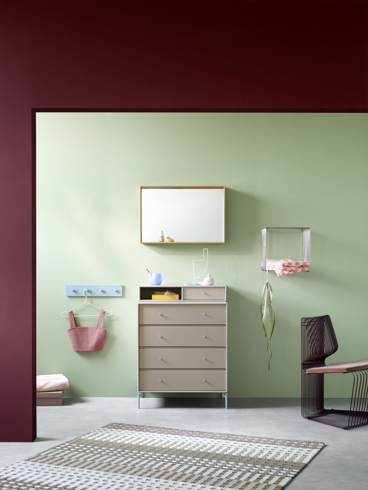 Innenraum mit Montana Kommode, Spiegel, und Pantonova Drahtstuhl in modernem Design.