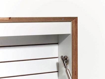 Detailaufnahme des weißen Flatbox Sekretärs von Müller Möbelwerkstätten mit Holzrahmen und Klappenmechanismus.