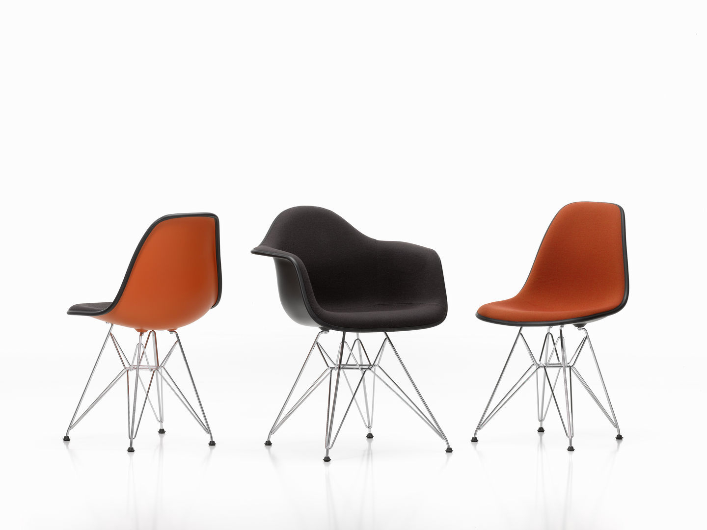 Drei Vitra Eames Plastic Side Chairs DSR mit Sitzpolster in warmgrey, elfenbein und kiesel.