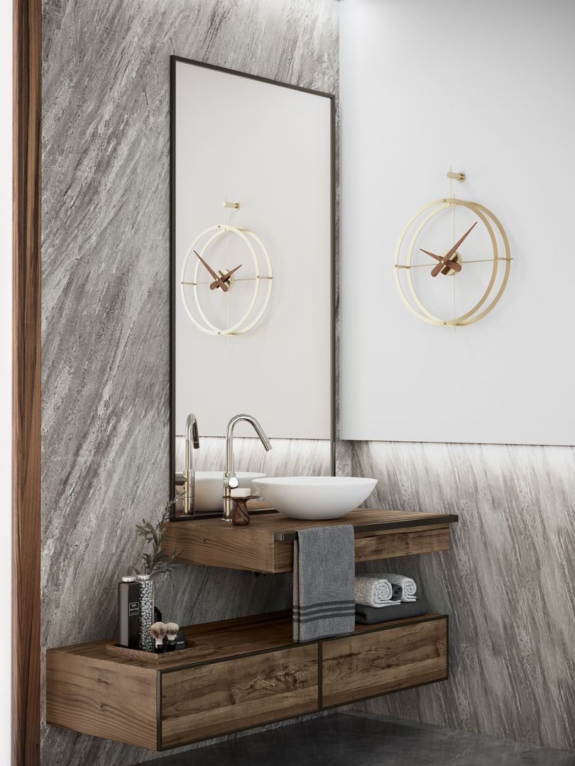 Goldene Nomon Uhr "2 Puntos" im Badezimmer über einem modernen Waschtisch. Design Wanduhr.
