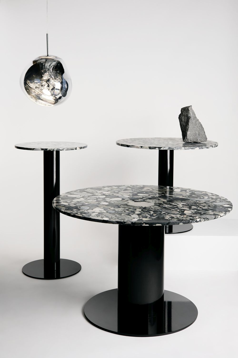 Nahaufnahme: Tom Dixon Melt LED Pendelleuchte in Chrom über Marmortischen, modernes Wohnambiente.
