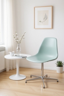 Mintgrüner Eames Fiberglass Side Chair DSL Stuhl von Vitra neben einem weißen Beistelltisch in einem hellen Raum.