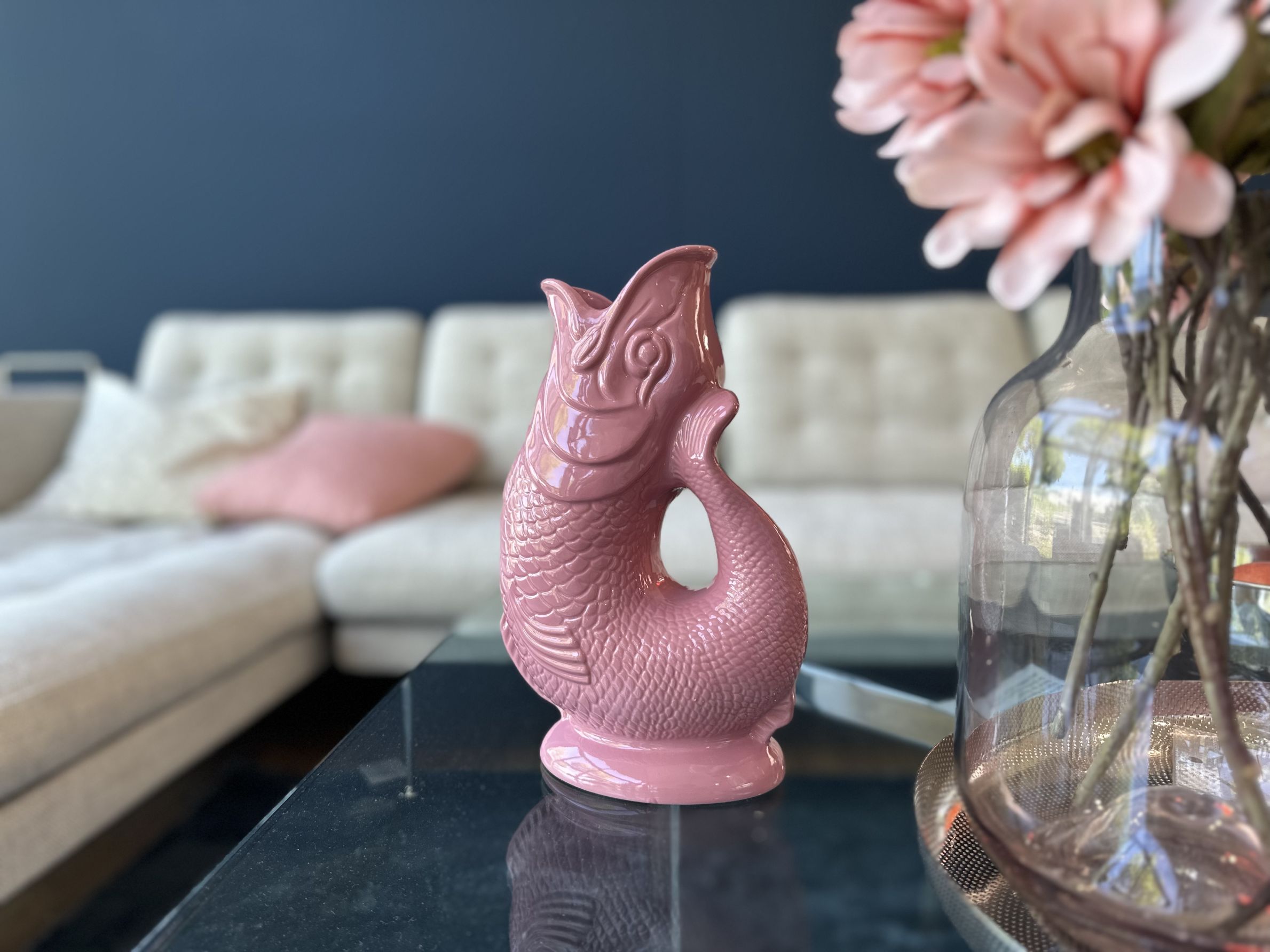 Rosa Fischvase aus Keramik auf einem Tisch, dekoratives Wohnaccessoire für Blumen und Pflanzen.