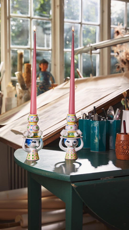 Zwei Lady with Hat Kerzenständer von Bjorn Wiinblad mit rosa Kerzen auf einem grünen Tisch.
