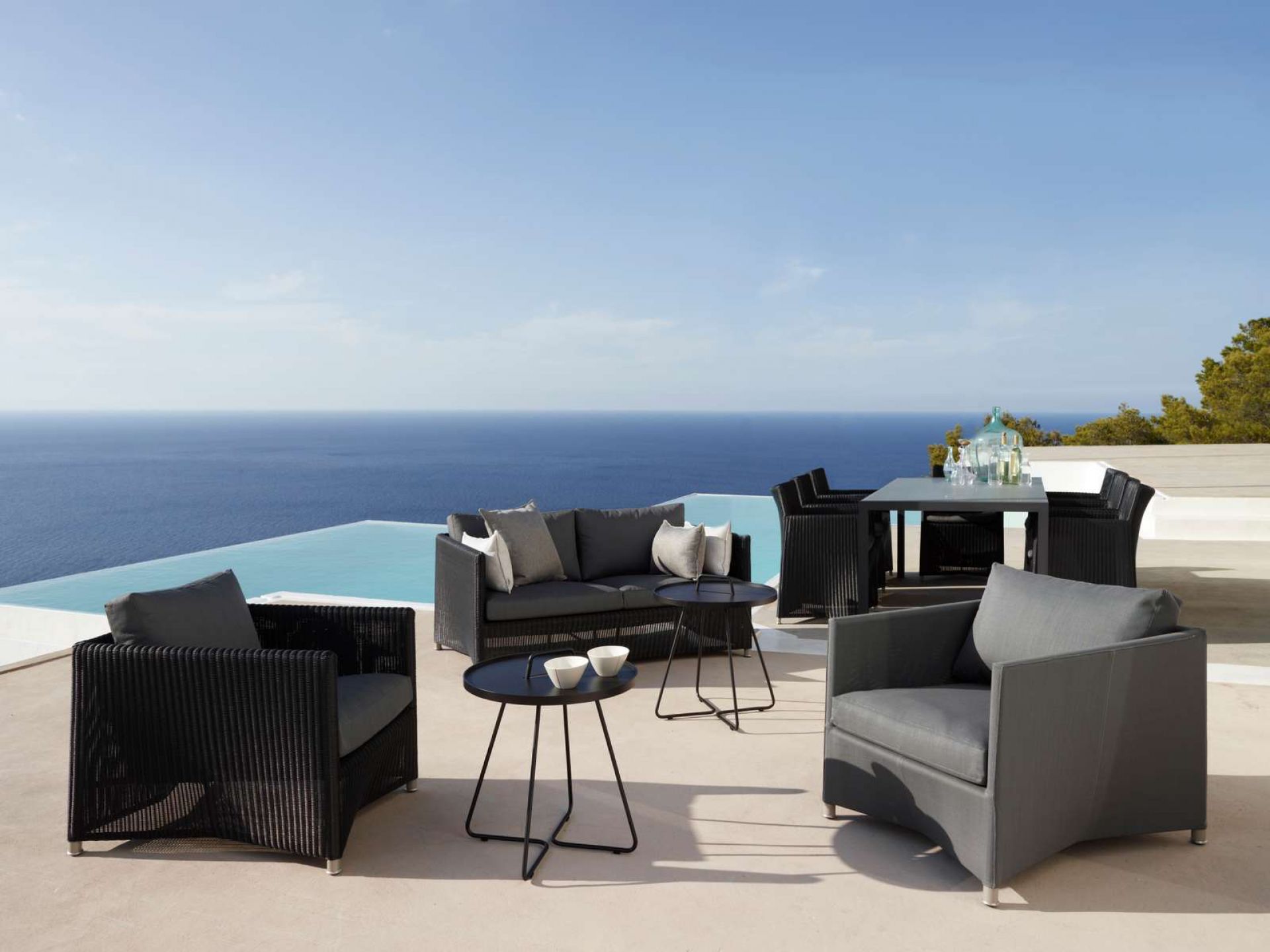 Luxuriöses Gartenmöbel-Set aus Rattan mit Sofa, Sesseln und Esstisch für Terrasse oder Balkon.
