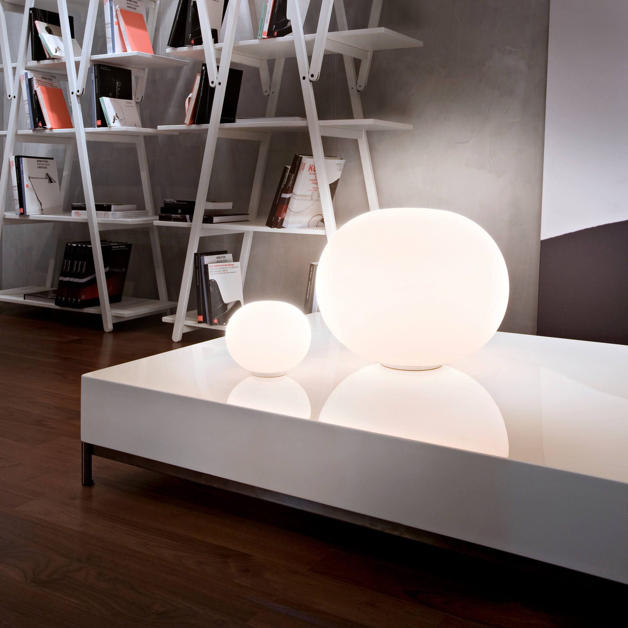 Zwei Glo Ball Tischleuchten von Flos auf einem weißen Tisch, moderne Beleuchtung.