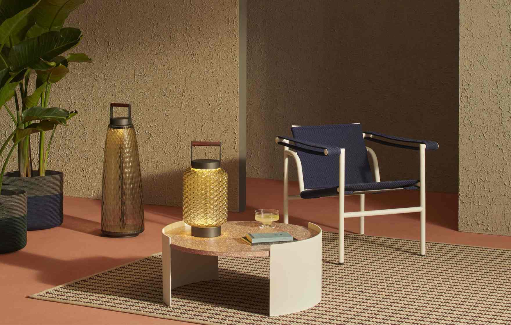 Cassina Ficupala Akkuleuchte: Goldene Outdoor Tischleuchte mit Stütze auf einem Beistelltisch.