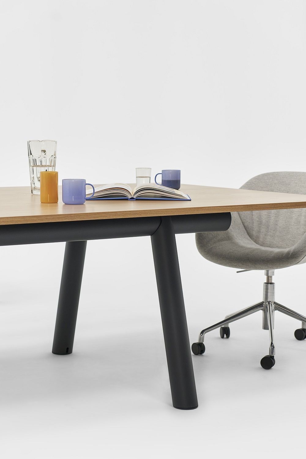 Hay Boa Table Tisch mit Eichenfurnier, schwarzen Beinen und dekorativen Accessoires im minimalistischen Büro.