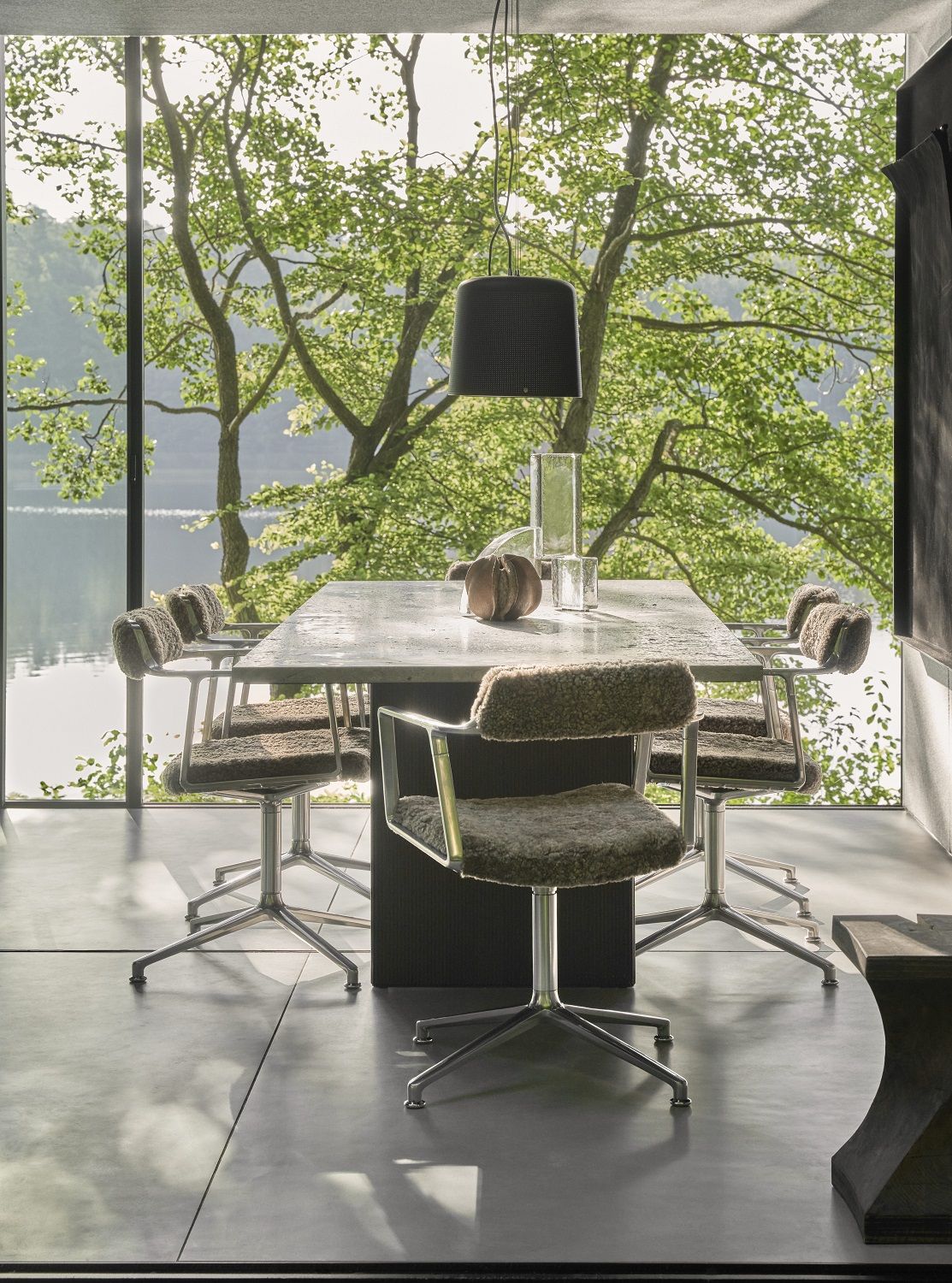 Innenaufnahme: Vipp Curly Stuhl Special Edition mit Gleitern am Esstisch vor Fenster mit Seeblick.