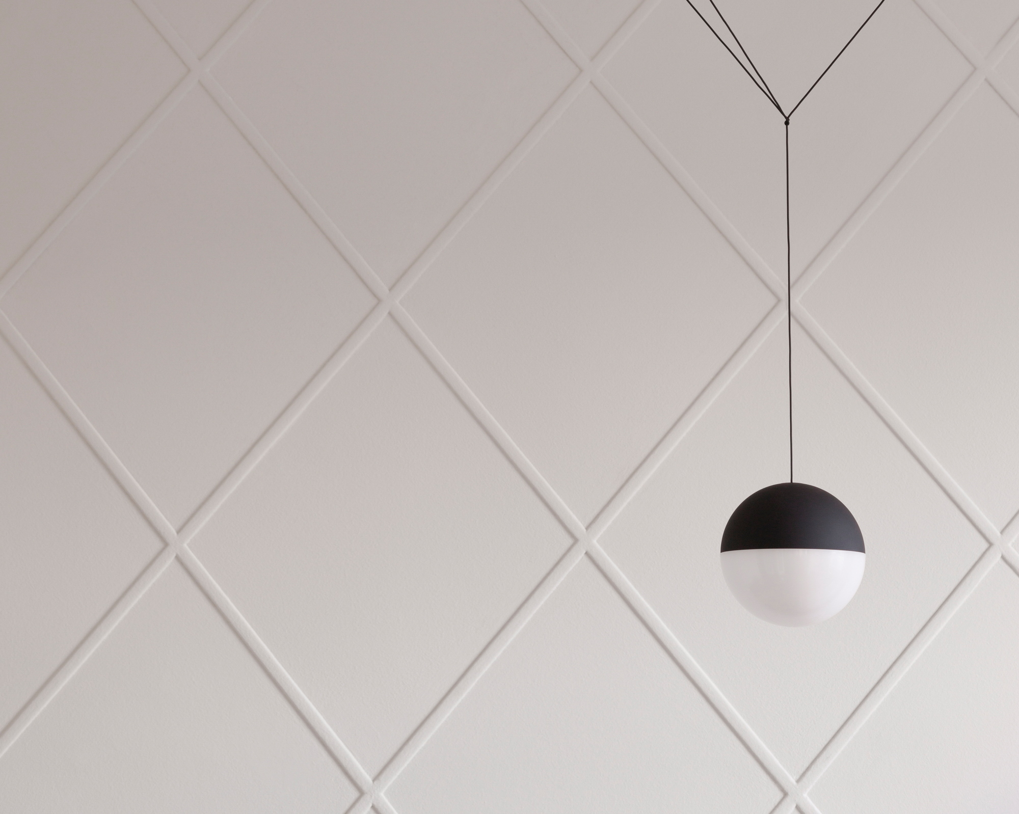 String Light Sphere Head Pendelleuchte von Flos: Moderne Hängeleuchte mit schwarzem und weißem Kugelkopf.