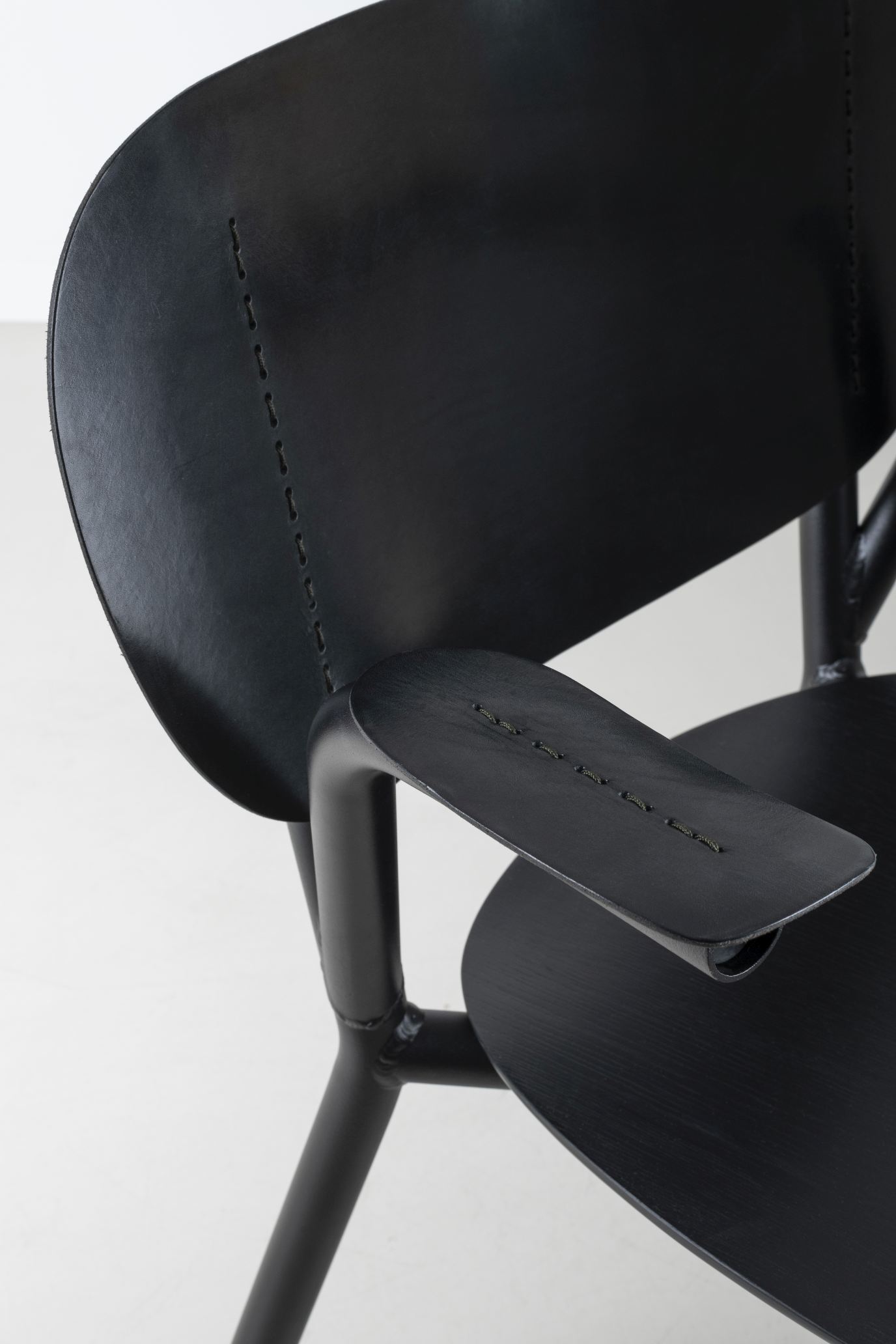 Detailaufnahme des Emil Rosi Armchair Stuhls von Functionals in Schwarz, Fokus auf Armlehne und Rückenlehne.