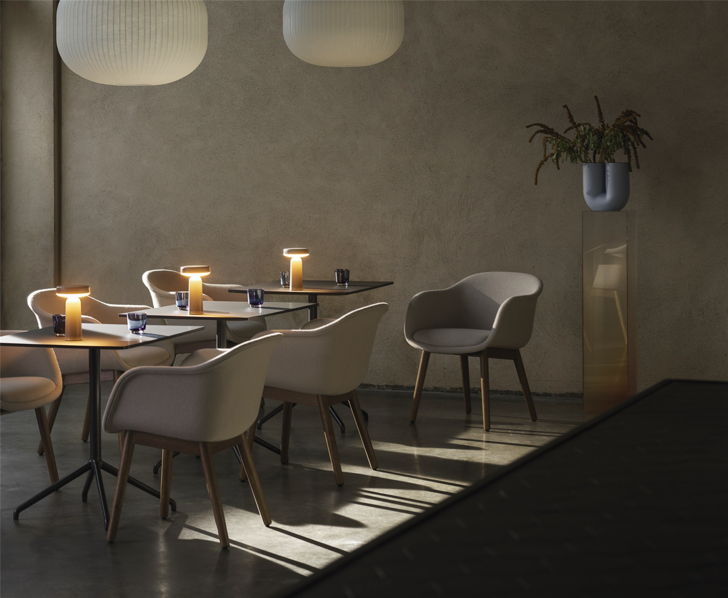 Innenaufnahme eines Restaurants mit modernen Stühlen, Tischen und Tischlampen für eine stimmungsvolle Beleuchtung.