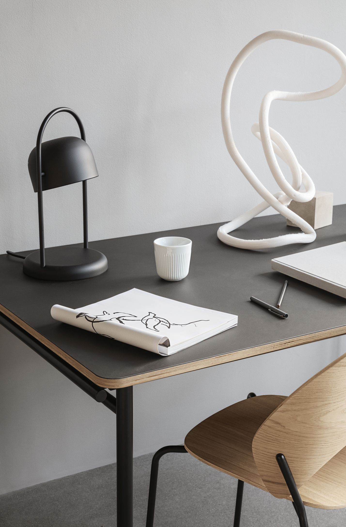 Detailaufnahme eines Dosina Stuhls von Eva Solo am Schreibtisch mit Lampe und Accessoires.