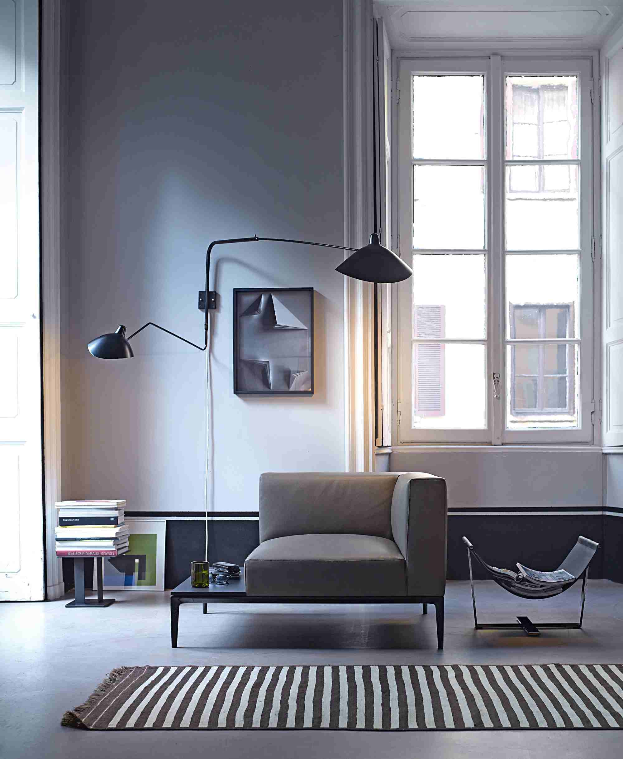 Moderner grauer 781 Jaan Sessel von Walter Knoll in stilvollem Wohnzimmer mit Teppich und Leselampe.