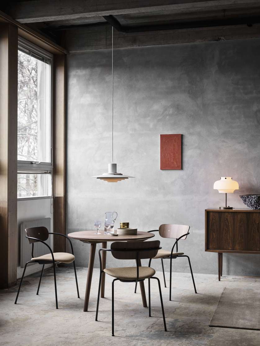 Pavilion AV4 Armchair Stuhl von AndTradition mit Armlehnen und Sitzpolster in einem Esszimmer.