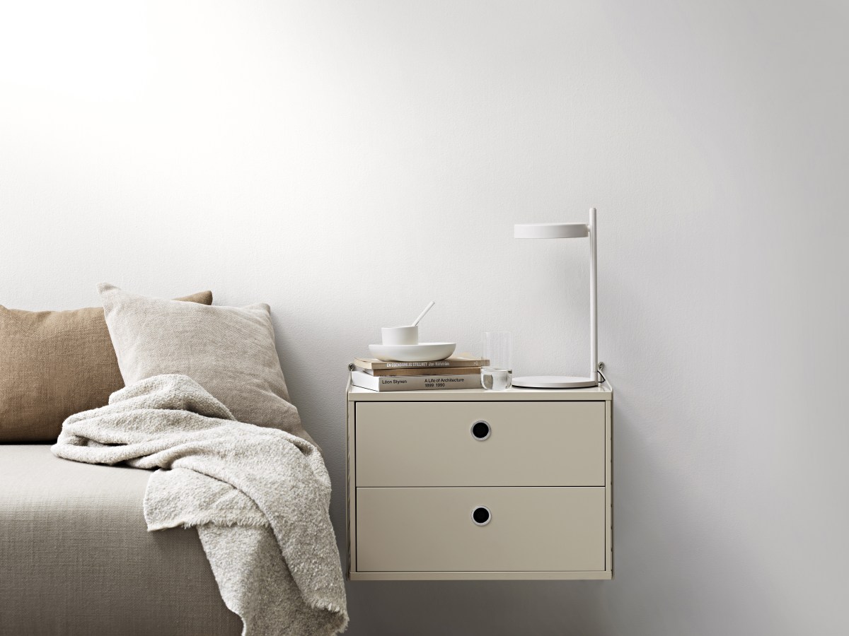 String Nachttisch im Schlafzimmer: Wandmontierter Nachttisch mit zwei Schubladen und Lampe.