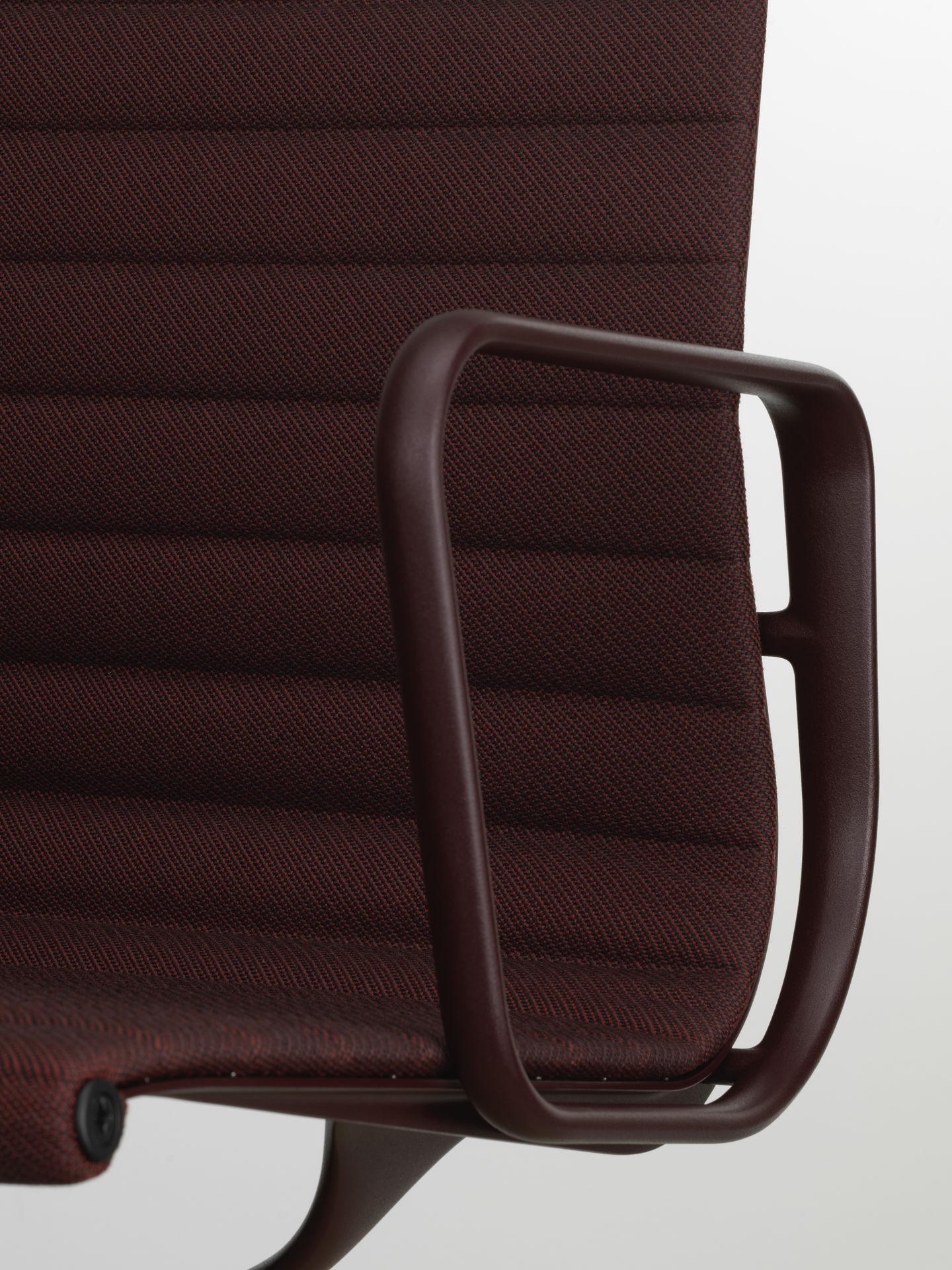 Detailaufnahme vom braunen Vitra EA 108 Aluminium Chair mit Armlehne und Stoffbezug.