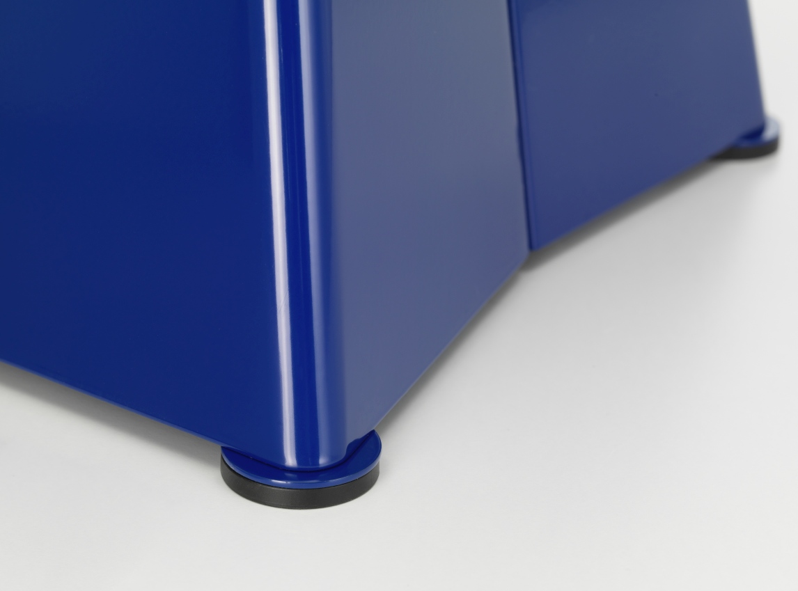 Detailaufnahme vom blauen Vitra Tabouret Métallique Hocker, der auf kleinen, runden Füßen steht.