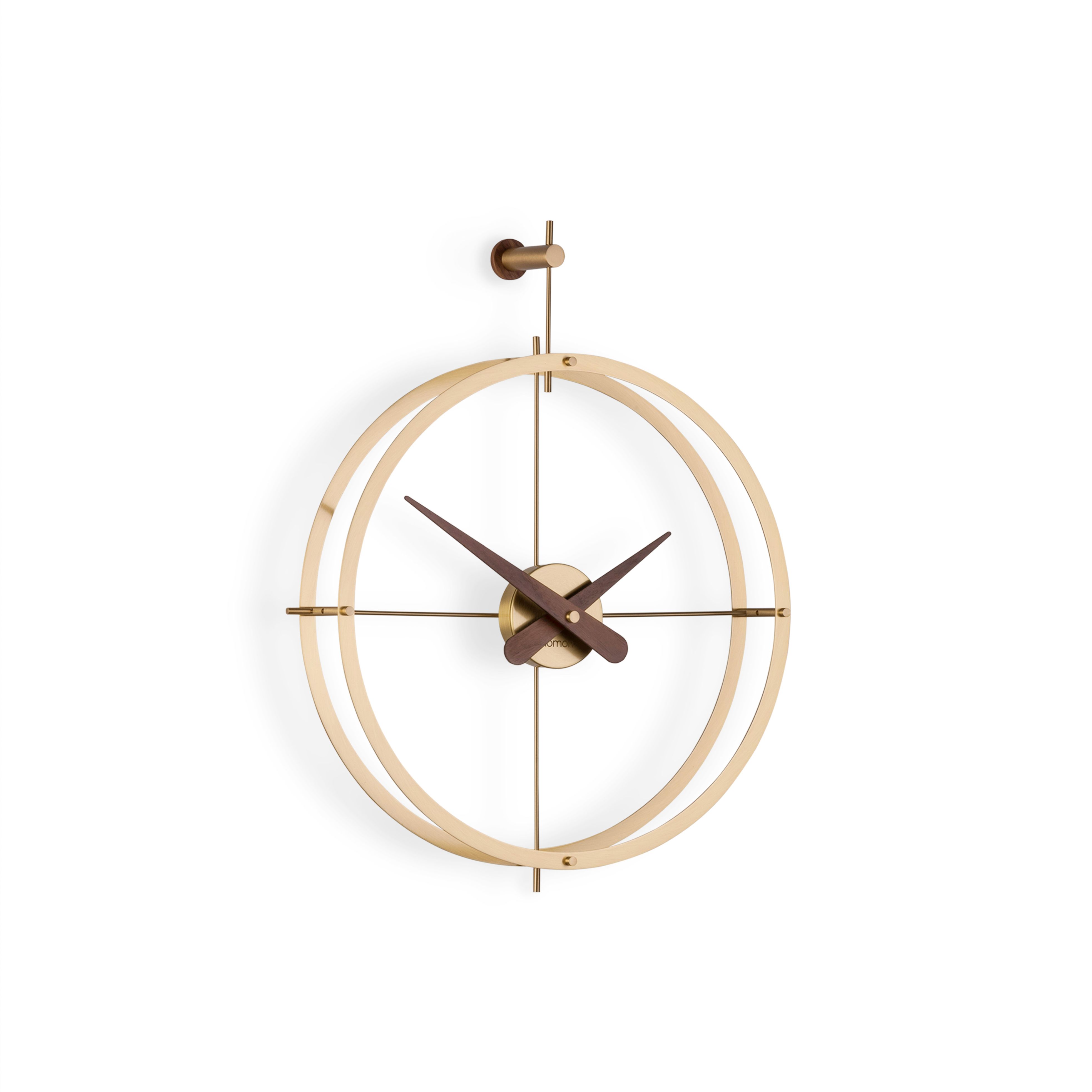 Nomon 2 Puntos Gold Wanduhr, modernes Design mit goldenen Ringen und Holzzeigern.
