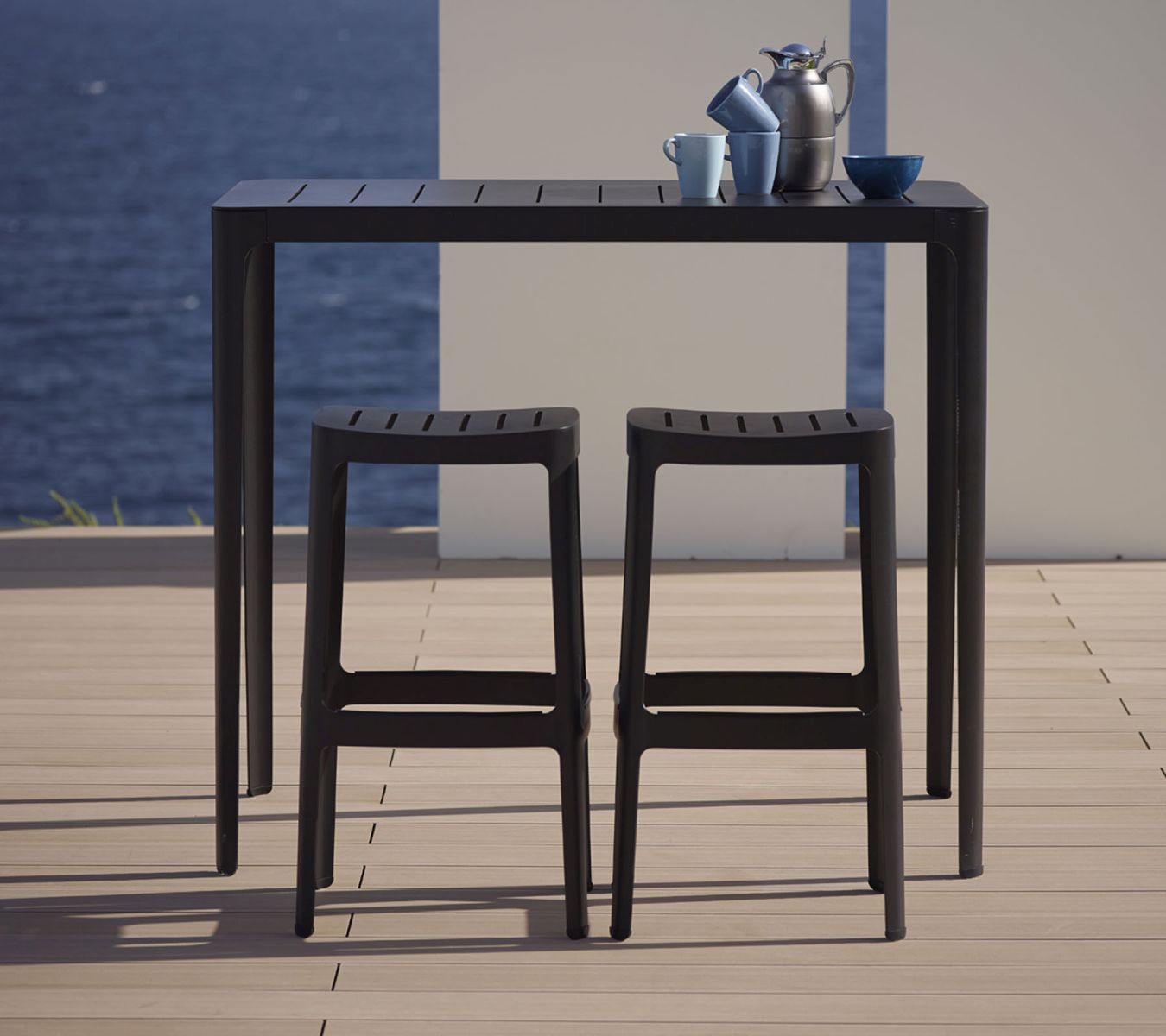 Schwarze Cut Barhocker von Cane-Line mit passendem Bartisch für den Außenbereich. Stapelbare Gartenmöbel.