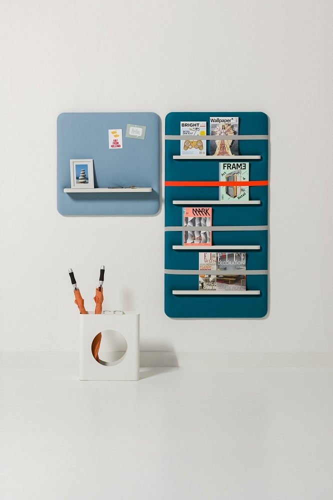 Cascando Pillow Wall Wandpaneele in Blau und Türkis mit Ablagefächern und Zeitschriften, Büroaccessoires im Vordergrund.