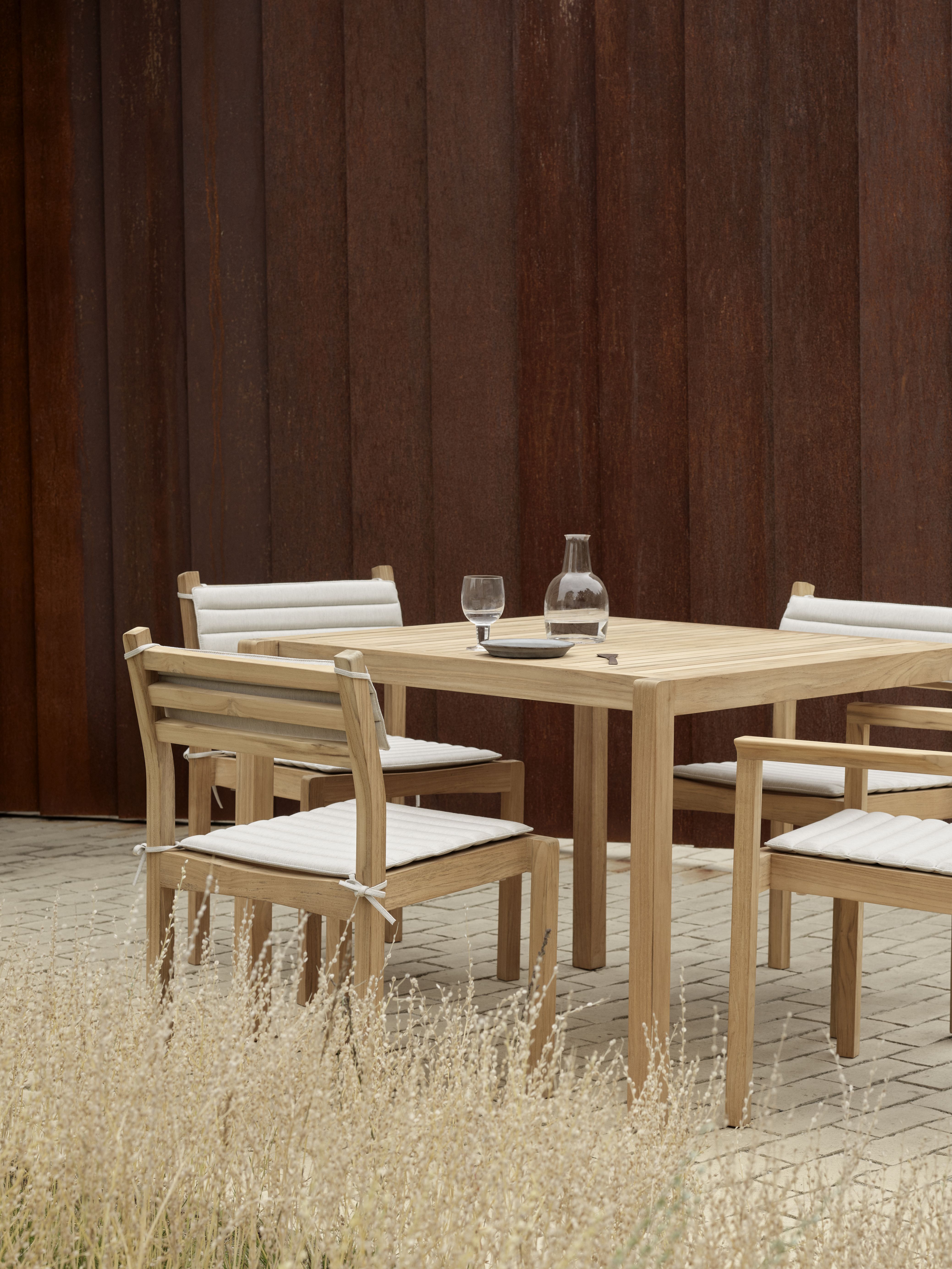AH902 Esstisch von Carl Hansen & Søn mit Stühlen und Tischdeko im Außenbereich.