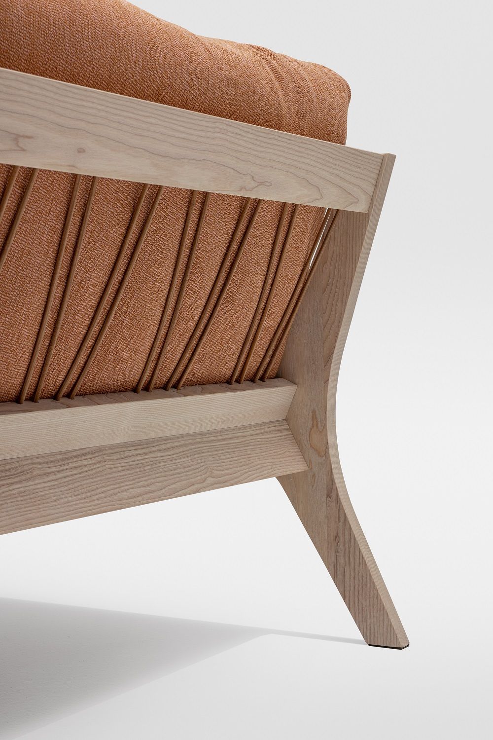 Detailaufnahme vom Mellow Bett Massivholz Zeitraum: Holzrahmen, Lattenrost und orangefarbenes Polster auf weißem Hintergrund.