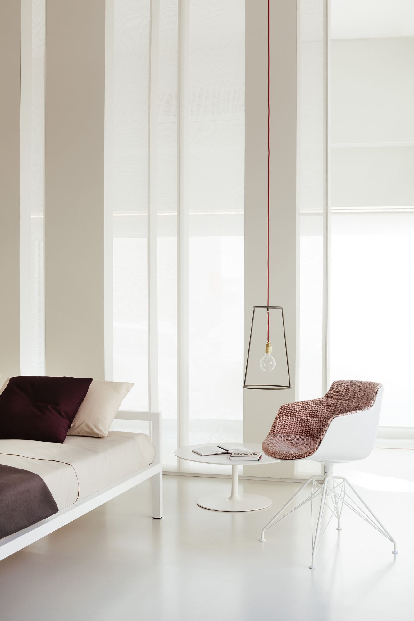 Minimalistisches Wohnzimmer mit MDF Italia Flow Low Table Couchtisch, Sessel und Bett in Weiß.