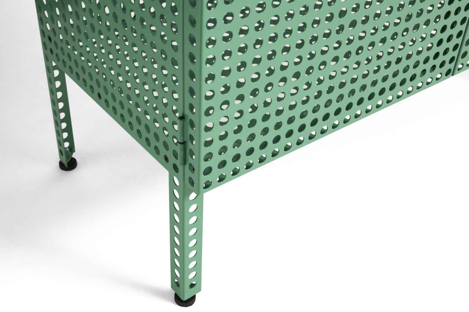 Detailaufnahme des grünen Hay Perforated Cabinet Sideboards mit Lochmuster und schwarzen Füßen auf weißem Hintergrund.