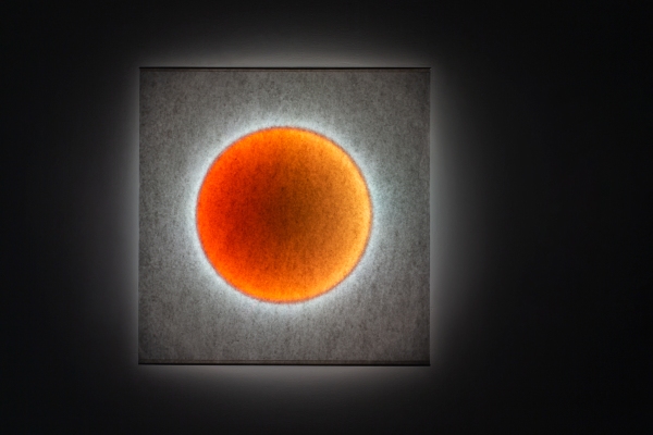 Moodmoon Wandleuchte: Quadratische Designerlampe mit orangem Lichtkreis für stimmungsvolle Beleuchtung im Wohnraum.
