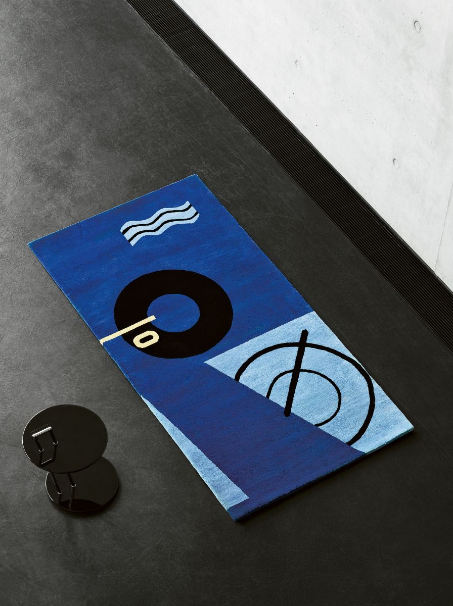 Blauer Design Teppich von ClassiCon, 179x350cm, mit abstrakten grafischen Mustern auf dunklem Untergrund.
