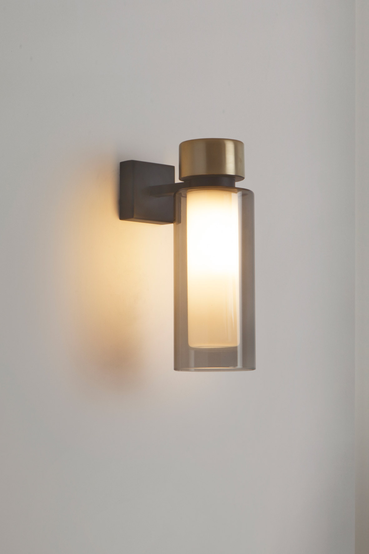 Osman Wandleuchte von Tooy: Moderne Wandlampe mit Glaszylinder und Messingdetails für stilvolle Beleuchtung.